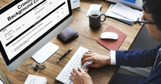 Worker sitting at computer with background check form