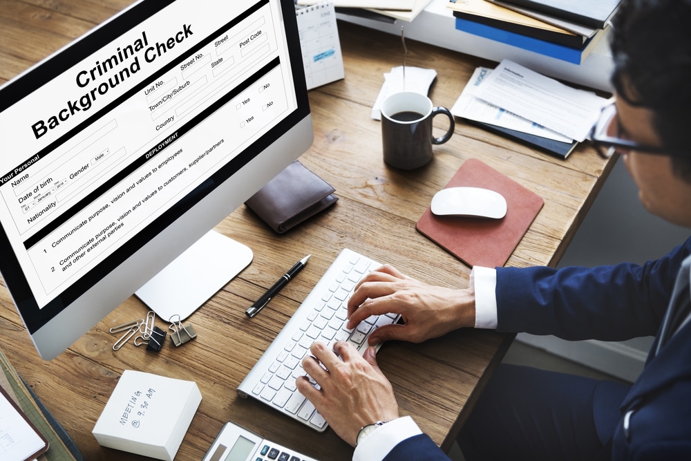 Worker sitting at computer with background check form