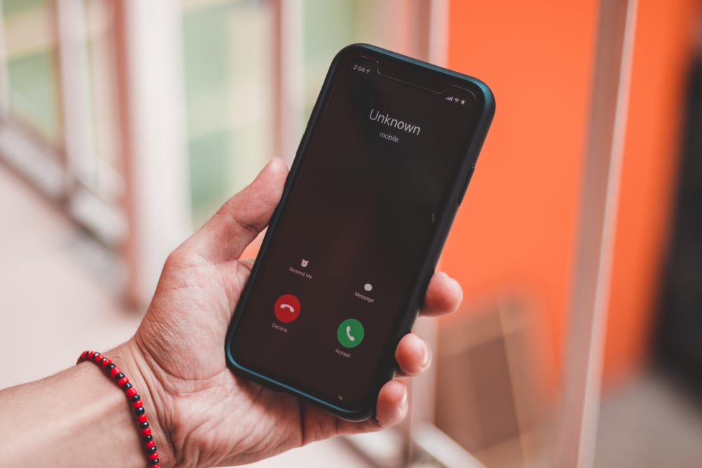 hand holding cell phone with unknown caller