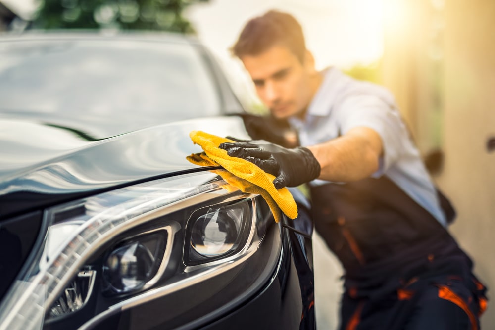 Man detailing car with microfiber cloth