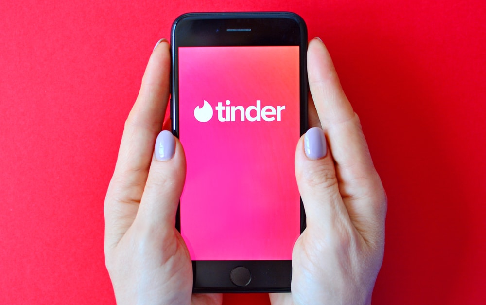 woman holding smartphone with tinder