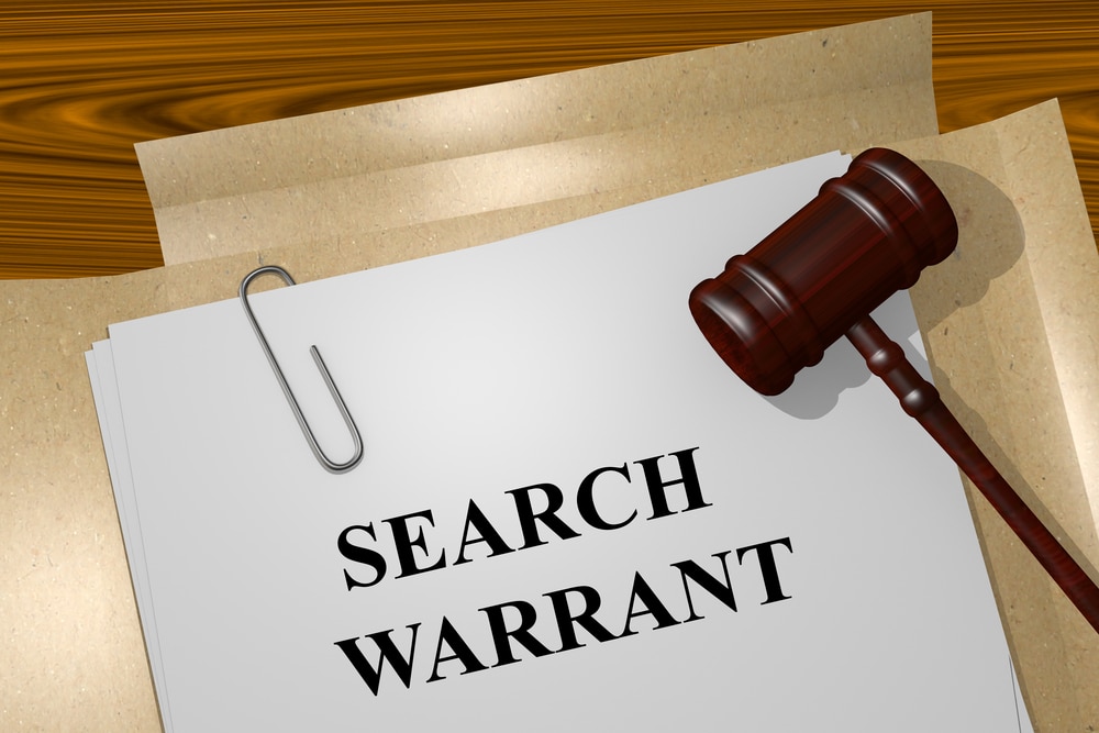 search warrant written on file with wooden gavel