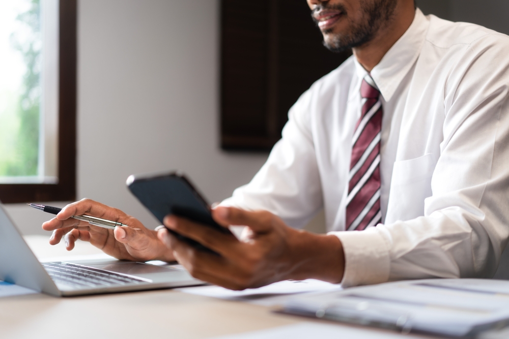 man using phone and computer