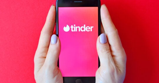 tinder logo on smartphone in hands