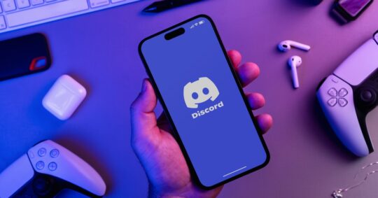 person holding phone with discord open