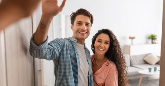 couple smiling and waving at someone
