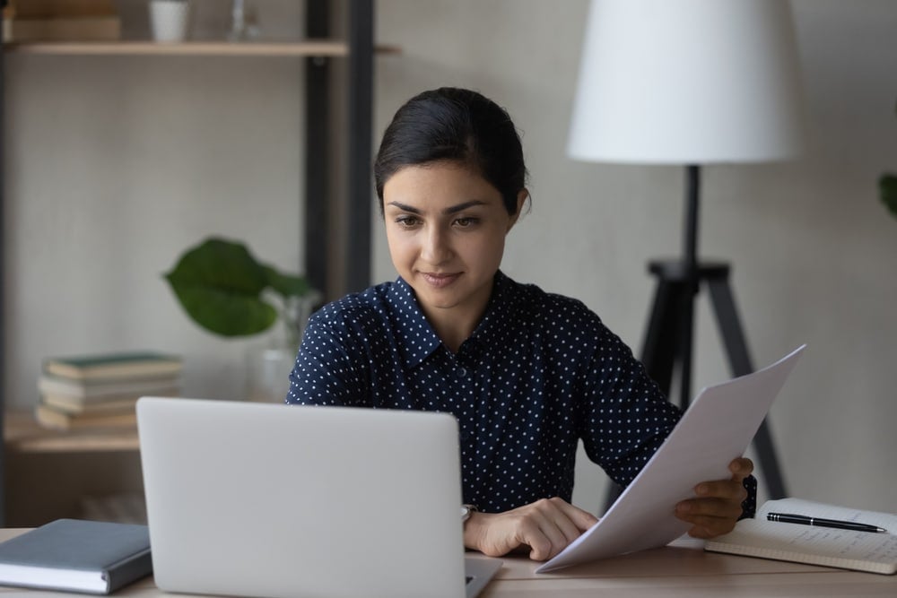 woman looking at documents in hand