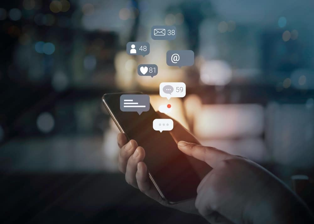 phone in hand with notification icons